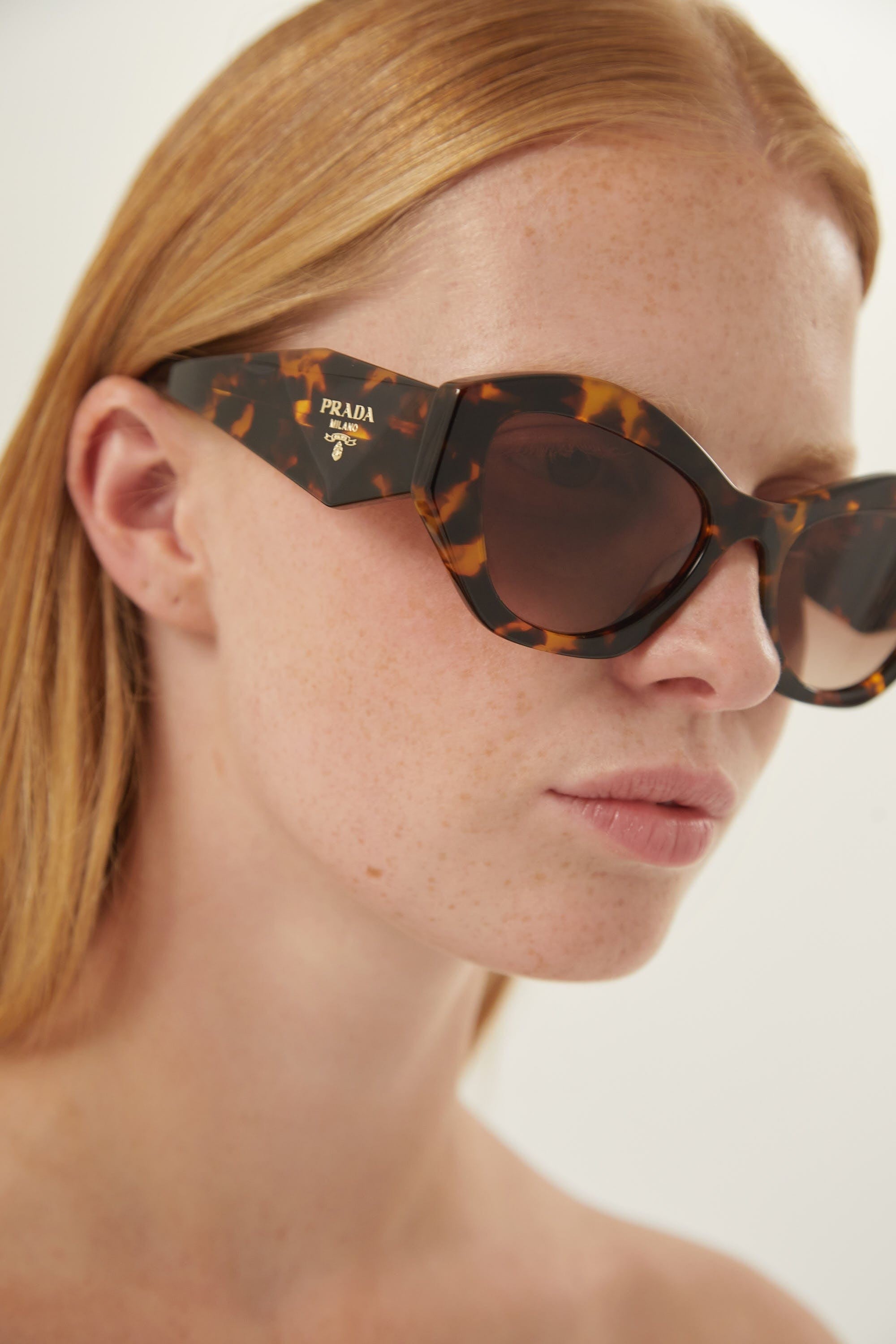 Prada oval sunglasses featuring iconic logo